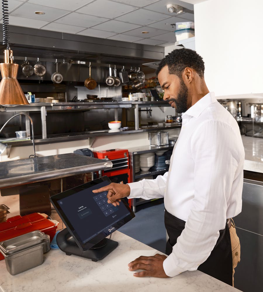 A chef using a kitchen management screen