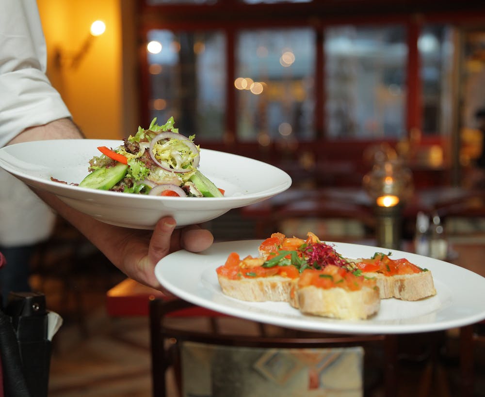 A waiter serving freshly prepared dishes